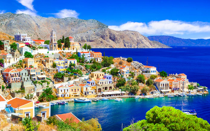 Panoramic view of colorful houses and boats in Symi harbor, Rhodes.