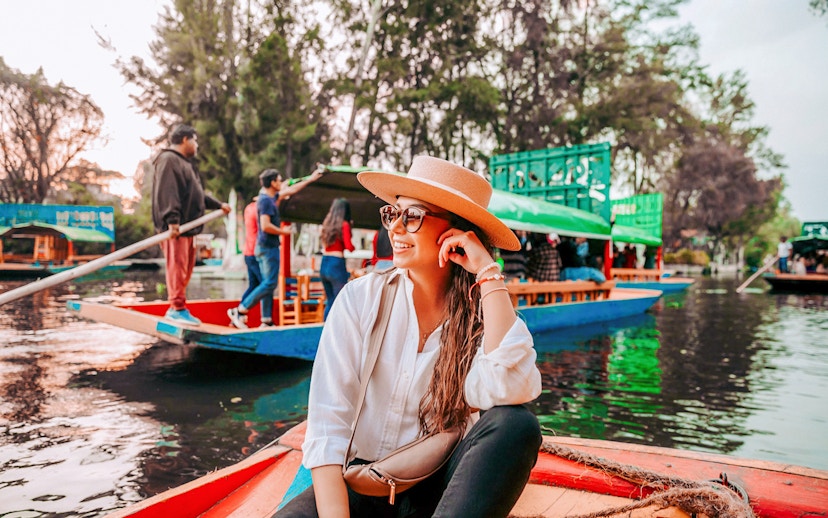 Tourist on a colorful boat enjoying the Xochimilco canals in Mexico City.