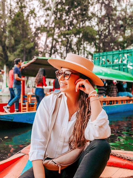 Tourist on a colorful boat enjoying the Xochimilco canals in Mexico City.