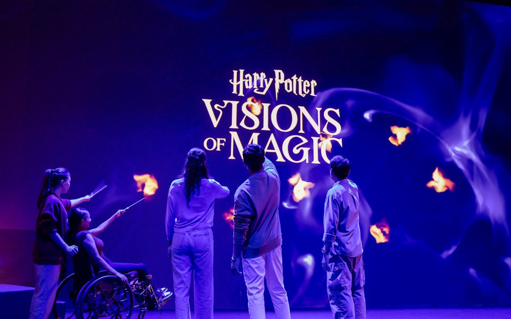 Group of people interacting with Harry Potter Visions of Magic display.