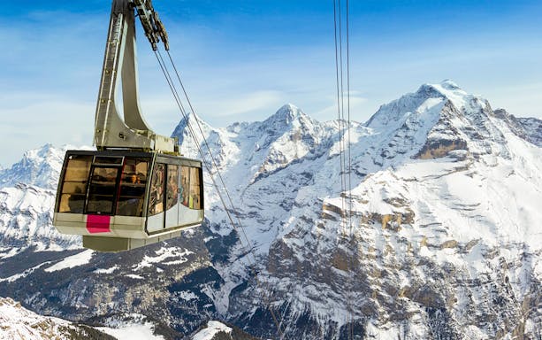 Schilthorn cable car with snowy Alps view on full-day Interlaken trip from Geneva.