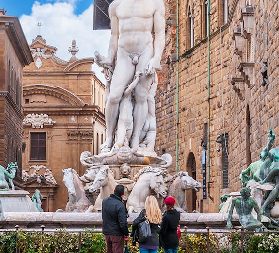 Fountain of Neptune in Piazza della Signoria, Florence, Italy with tourists observing.