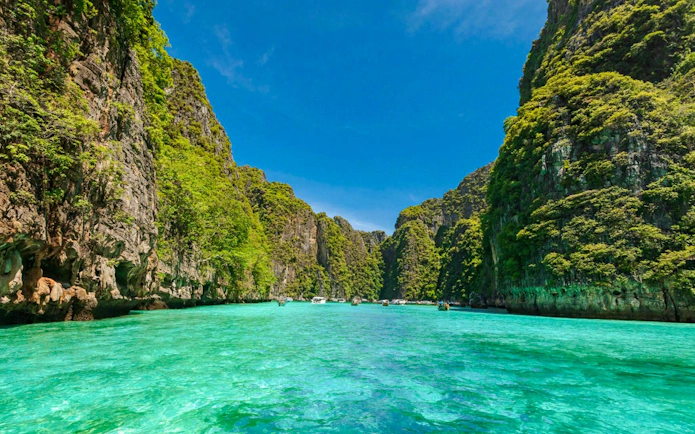 Catamaran tour through turquoise waters and limestone cliffs of Phi Phi Islands, Phuket.