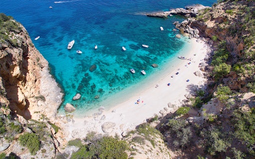 Aerial view of boats near a secluded beach on the Baunei Coast, Sardinia.