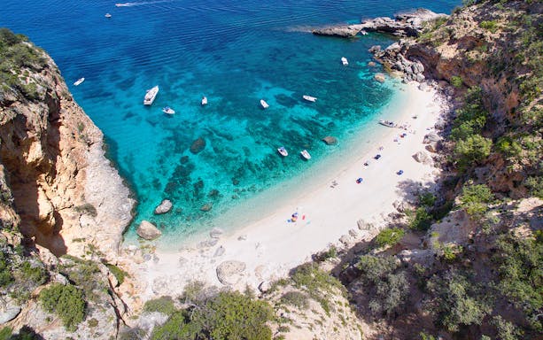 Aerial view of boats near a secluded beach on the Baunei Coast, Sardinia.