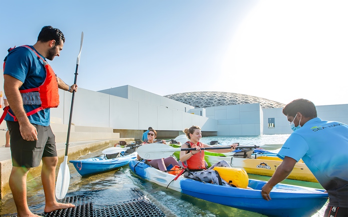 Visitors preparing for a guided kayak tour at Louvre Abu Dhabi.