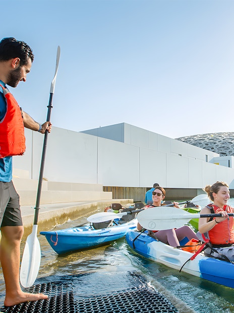 Visitors preparing for a guided kayak tour at Louvre Abu Dhabi.