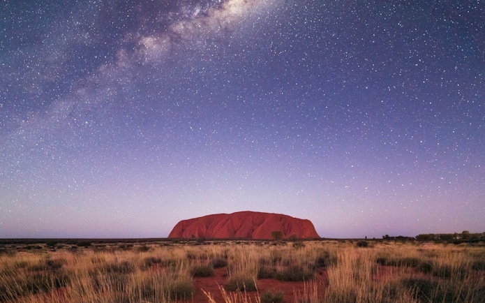 Uluru under a starry night sky during the Outback Camping Adventure.
