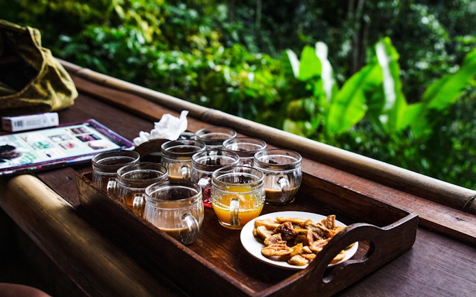 Coffee tasting setup with various cups and snacks in Bali.