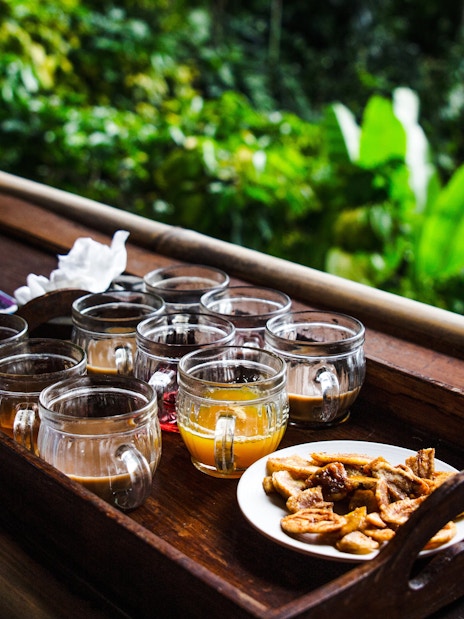 Coffee tasting setup with various cups and snacks in Bali.