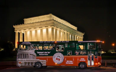 Tour bus in front of illuminated Lincoln Memorial at night, Washington, DC.