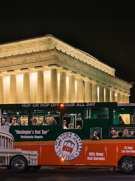 Tour bus in front of illuminated Lincoln Memorial at night, Washington, DC.