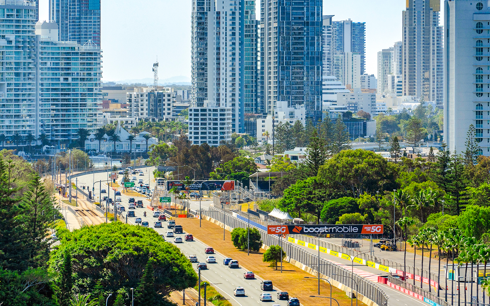 Gold Coast highway with city skyscrapers and lush greenery in the background.