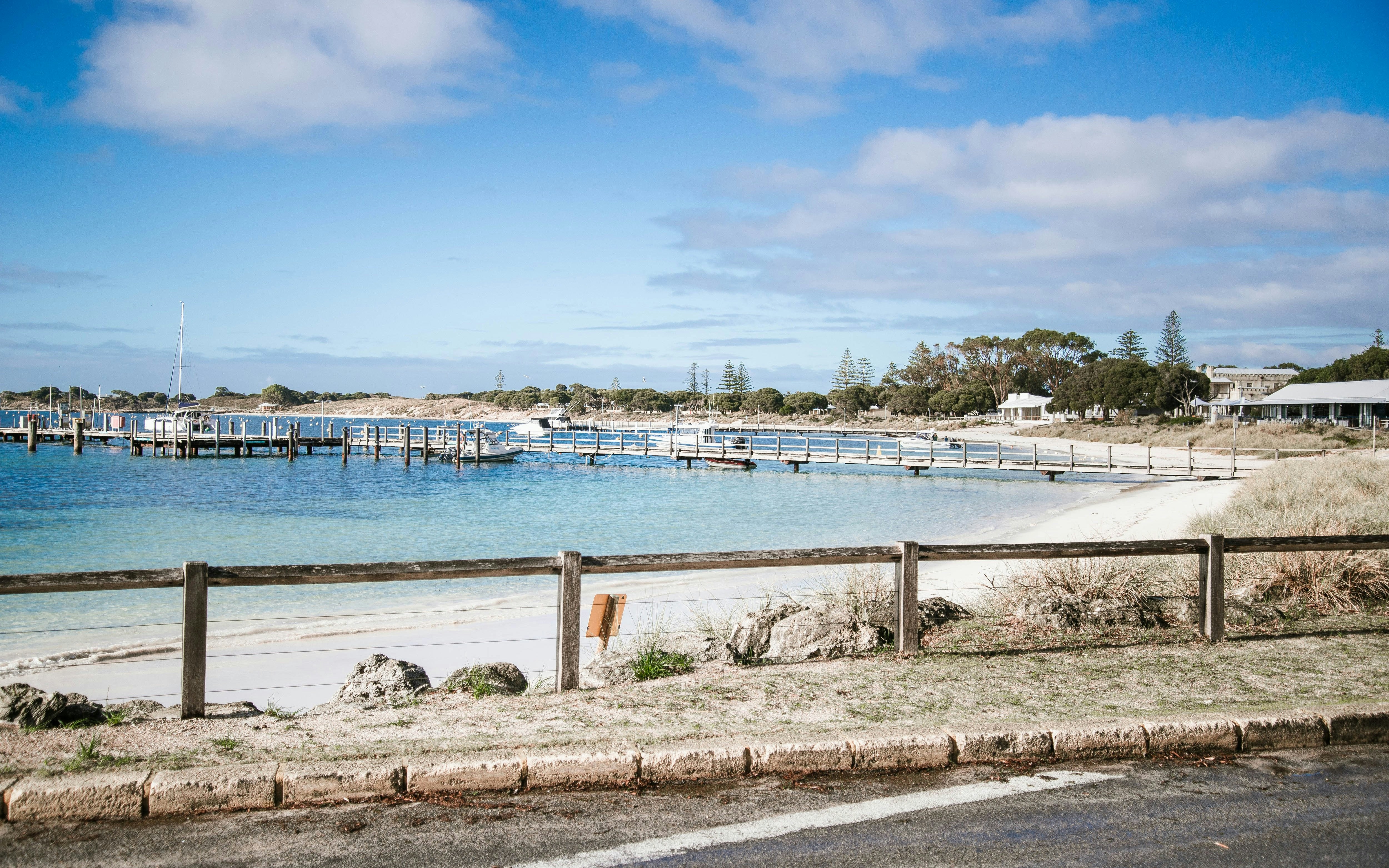 Road beside Thomson Bay with boats docked at Rottnest Island, Australia.