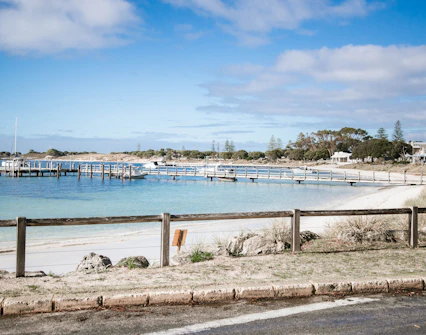 Road beside Thomson Bay with boats docked at Rottnest Island, Australia.