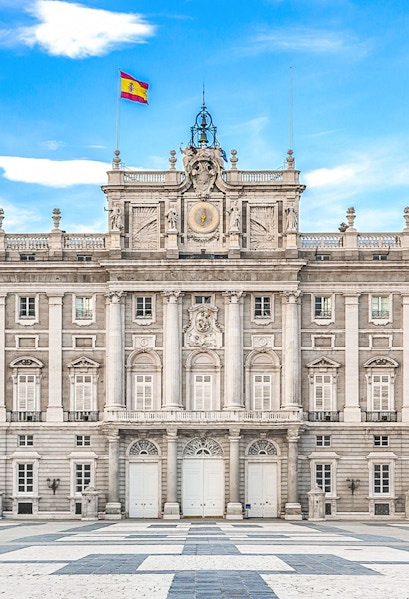 Royal Palace of Madrid facade with Spanish flag, Madrid, Spain.