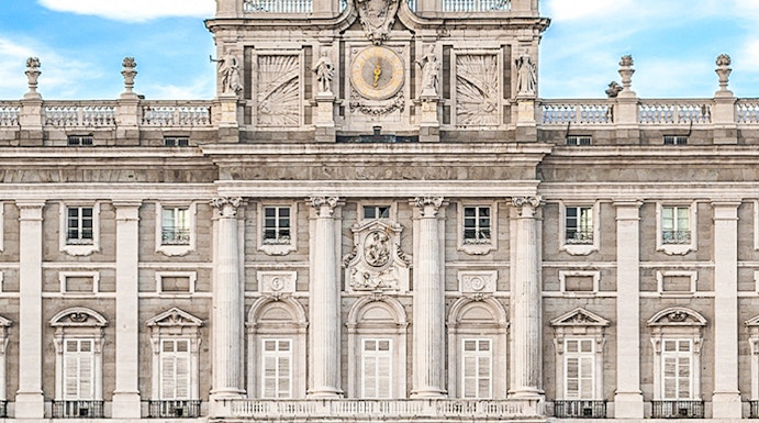 Royal Palace of Madrid facade with Spanish flag, Madrid, Spain.