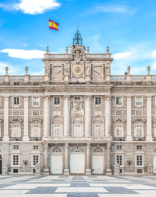 Royal Palace of Madrid facade with Spanish flag, Madrid, Spain.