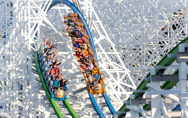 Roller coaster with riders at Six Flags Magic Mountain, California.