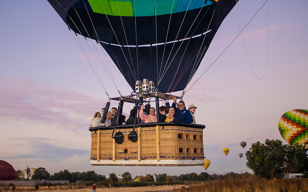 Hot air balloon with passengers over Teotihuacan at sunrise.