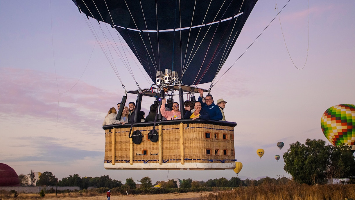 Hot air balloon with passengers over Teotihuacan at sunrise.