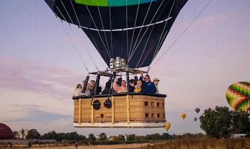 Hot air balloon with passengers over Teotihuacan at sunrise.
