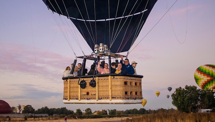 Hot air balloon with passengers over Teotihuacan at sunrise.