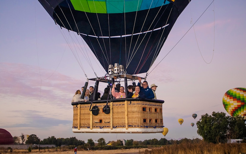 Hot air balloon with passengers over Teotihuacan at sunrise.