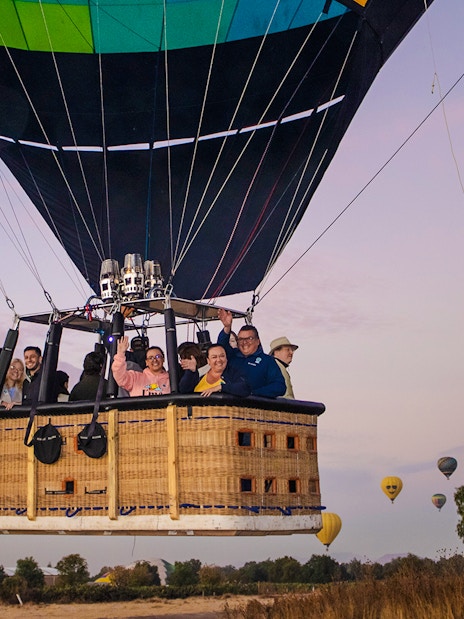 Hot air balloon with passengers over Teotihuacan at sunrise.