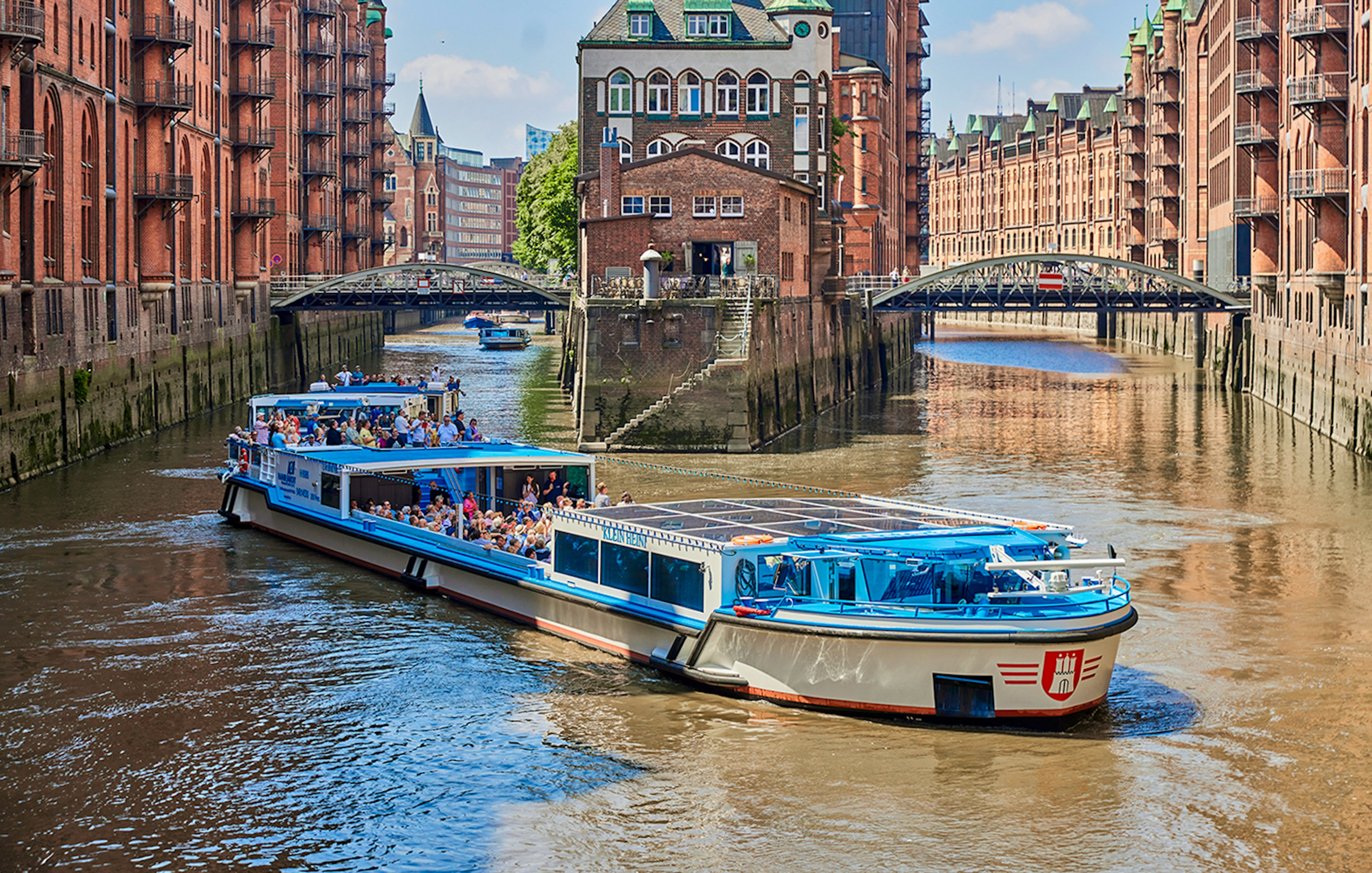 Boat tour through Hamburg's historic warehouse district with red brick buildings.