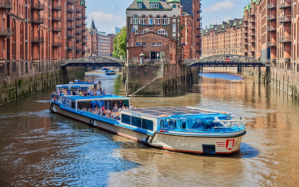 Boat tour through Hamburg's historic warehouse district with red brick buildings.