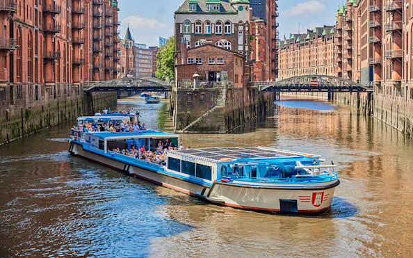 Boat tour through Hamburg's historic warehouse district with red brick buildings.