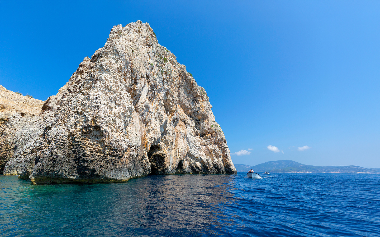 Tourists approaching Blue Cave by boat on Bisevo Island, Croatia.