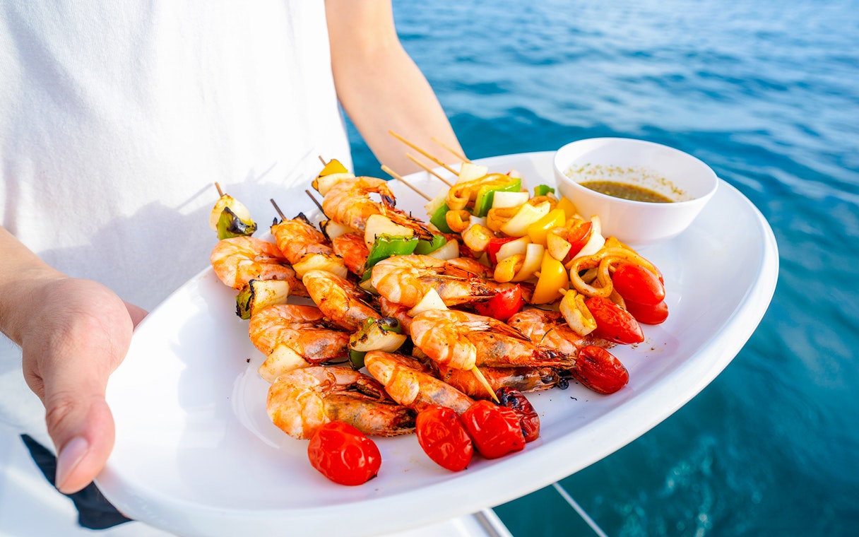Seafood platter with grilled shrimp and vegetables on a cruise.