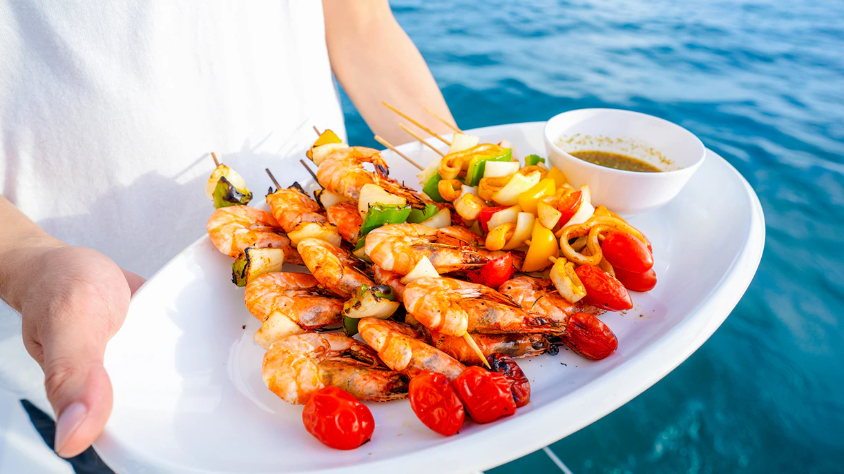 Seafood platter with grilled shrimp and vegetables on a cruise.