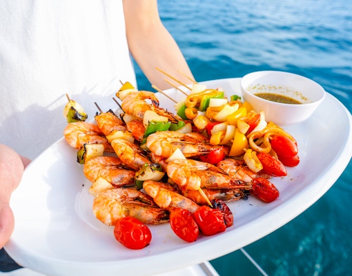 Seafood platter with grilled shrimp and vegetables on a cruise.