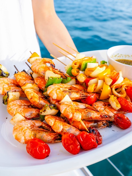 Seafood platter with grilled shrimp and vegetables on a cruise.