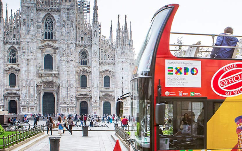 Open-top bus near Milan Cathedral on city sightseeing tour.