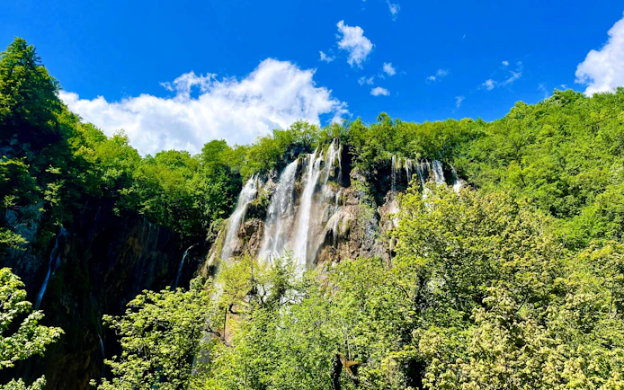 Aerial view of waterfalls surrounded by lush greenery in Plitvice National Park, Croatia.