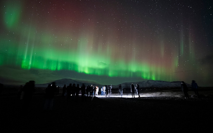 Tour group watching Northern Lights near Reykjavik.