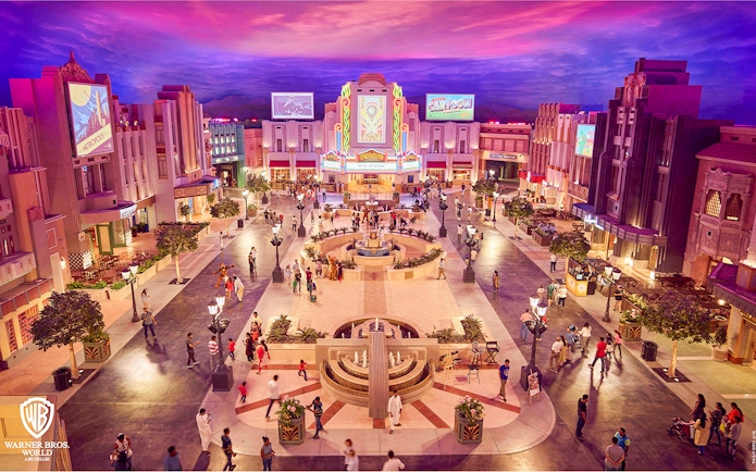 Warner Bros. World™ Abu Dhabi plaza with visitors and vibrant architecture.
