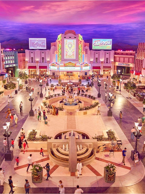 Warner Bros. World™ Abu Dhabi plaza with visitors and vibrant architecture.