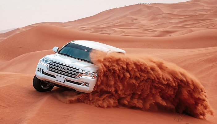 A vehicle on red sand dunes
