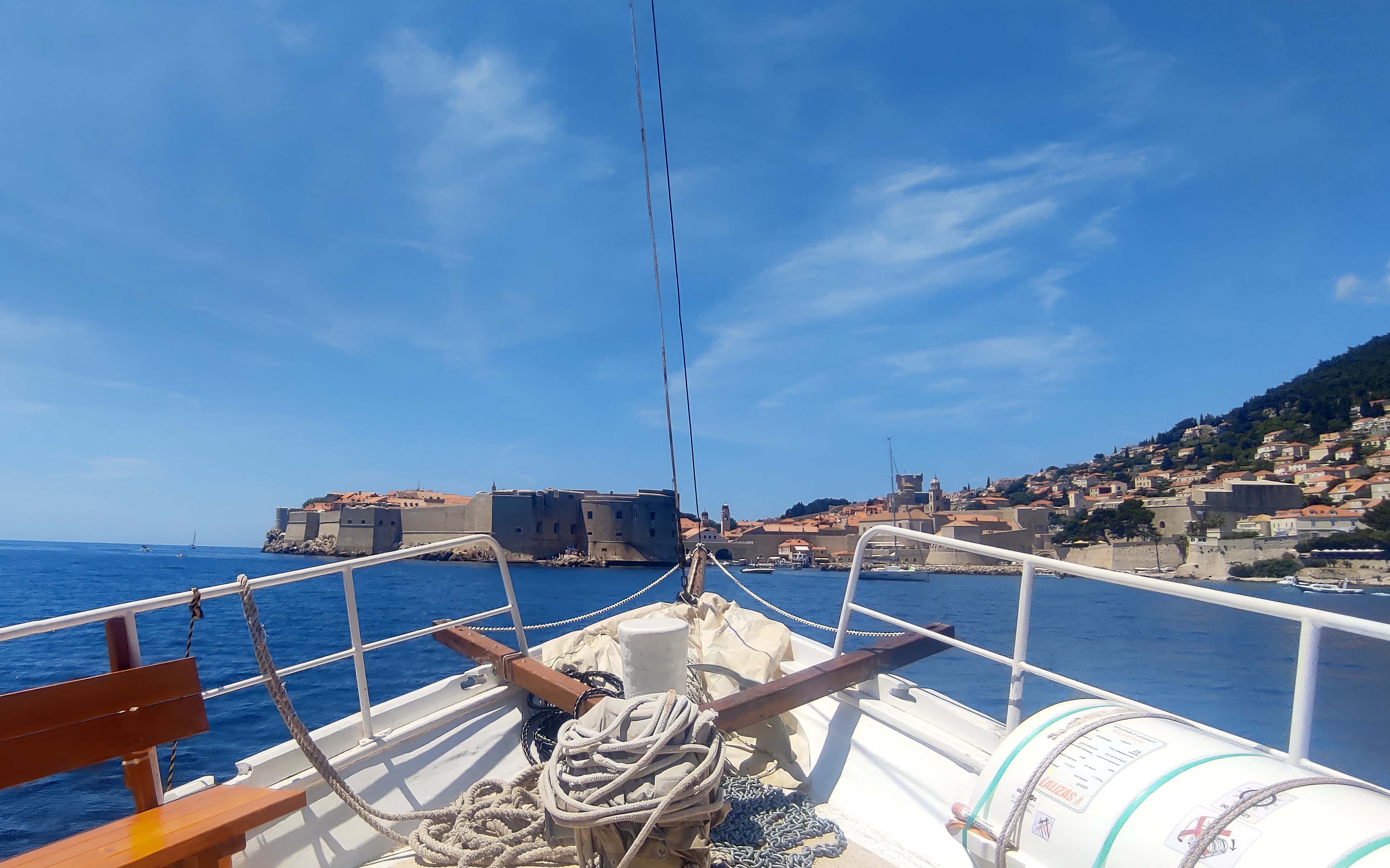 Boat approaching Dubrovnik's historic city walls, view from deck.