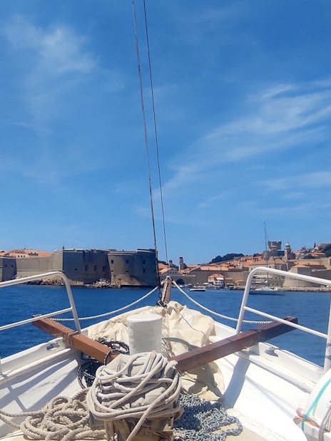 Boat approaching Dubrovnik's historic city walls, view from deck.