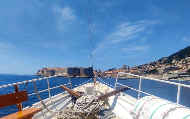 Boat approaching Dubrovnik's historic city walls, view from deck.