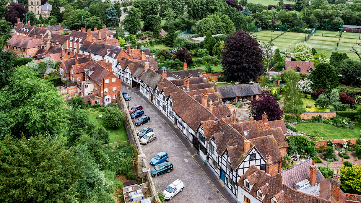 Aerial view of parking area near historic buildings at Warwick Castle, England.