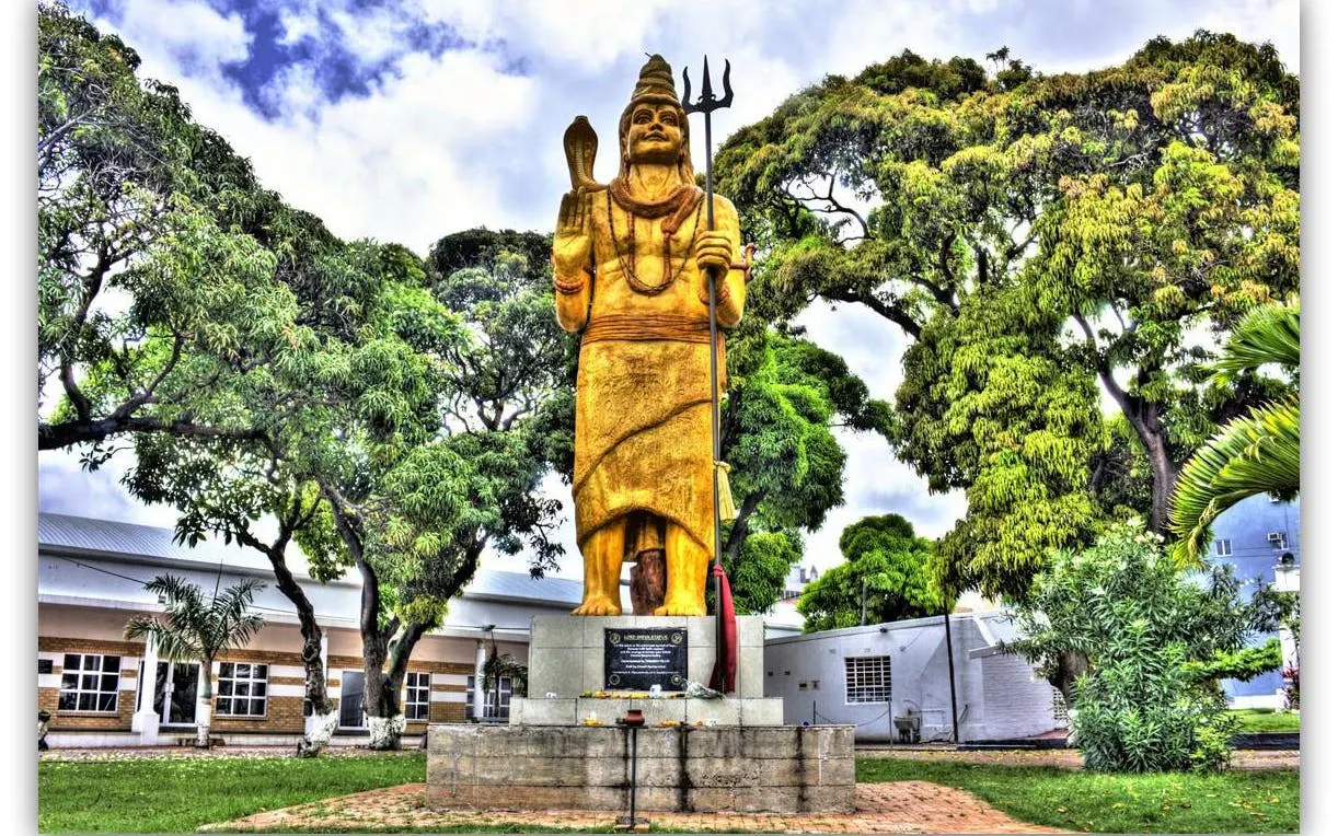 Statue of Lord Shiva at Shri Vishnu Temple in Durban, surrounded by trees.