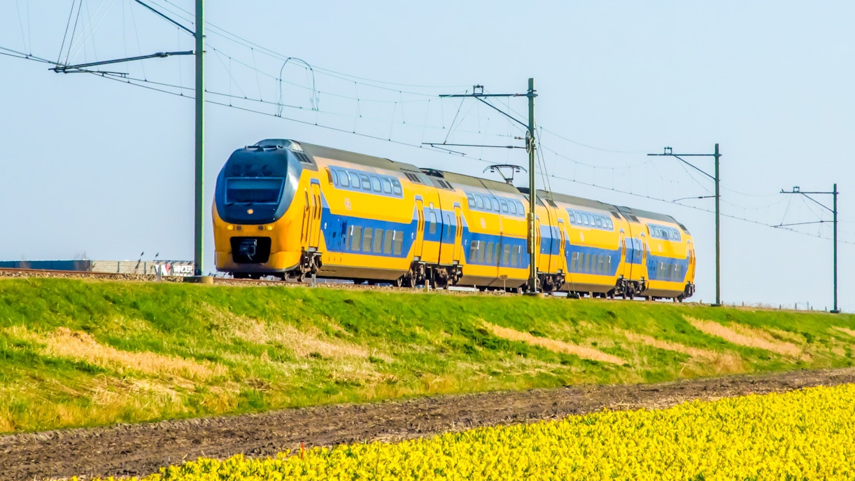 Train traveling through Dutch countryside near Amsterdam Centraal.