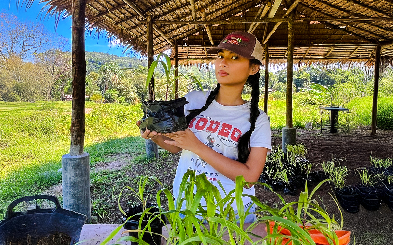 Woman holding corn plant at Bukit Elephant Park.